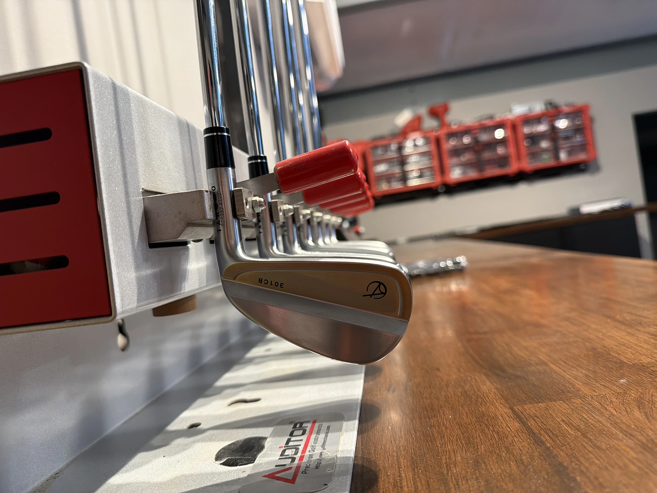 Iron secured in a loft and lie adjustment machine