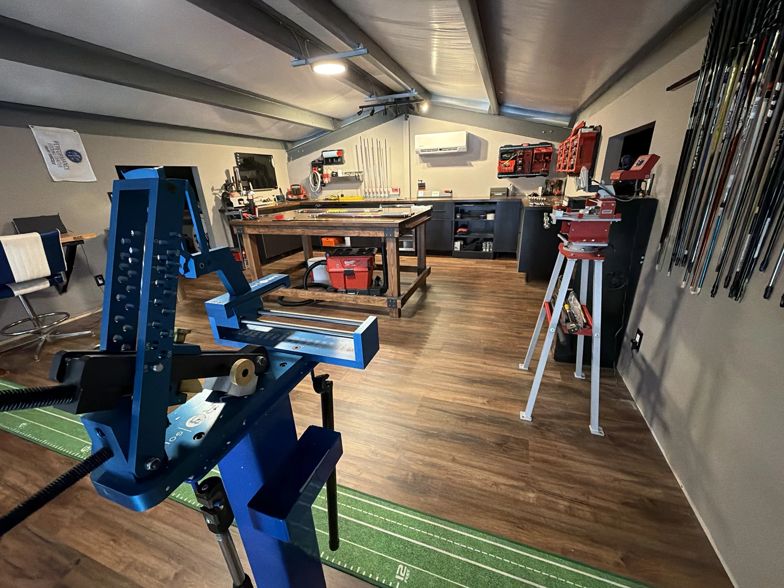 Club-building workshop with equipment, shafts, and workbench